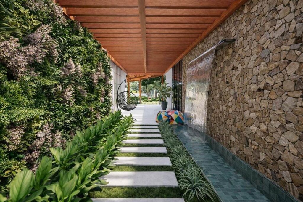 Corredor com jardim vertical e espelho d'agua
