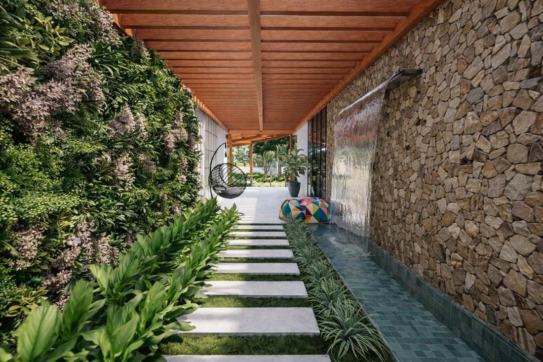 Corredor com jardim vertical e espelho d'agua
